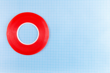 red adhesive tape lies on a blue checkered background