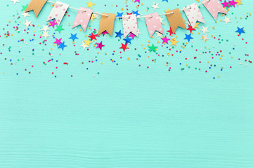 Party colorful confetti over light pastel blue wooden background . Top view, flat lay