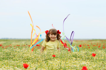 happy little girl fun and waving with colorful ribbons on meadow spring season