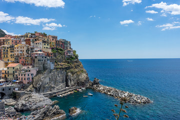 Italy, Cinque Terre, Manarola, Cinque Terre, a large body of water with buildings in the background with Cinque Terre in the background