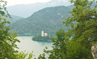 Top view of Lake Bled, trees, Julian Alps mountains and church on the island, Bled, Slovenia