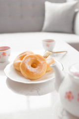 Classic donut. Morning breakfast with tea on table in living room at home.