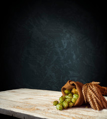 Beer, brewery background. Fresh green hop and wheat with wooden barrel on vintage table. Ingredients for brewing. Retro style. Beer brewing traditions. Copy space for your text