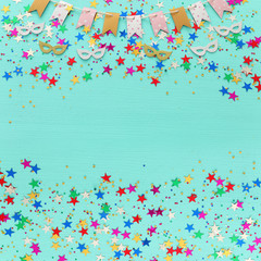 Party colorful confetti over light pastel blue wooden background . Top view, flat lay