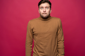 Obraz premium Nervous embarassed man, looks worried before visiting doctor or dentist. Anxious concerned male student feels anxiety before passing course or diploma paper, afraid of difficult questions.