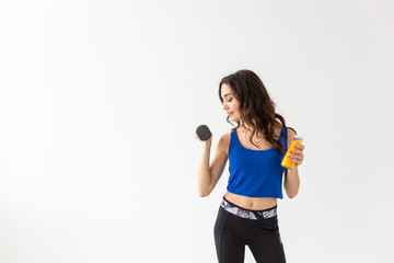 Sport, healthy lifestyle, people concept - young woman holds bottle of juice and a dumbbell on white background with copy space