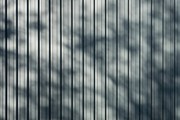 Gray folded titanium sheet metal roof with drop shadow from tree background, Flat background photo texture