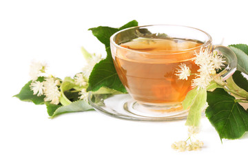 Linden tea on a white table in a glass cup. Flower tea, herbal medicine.