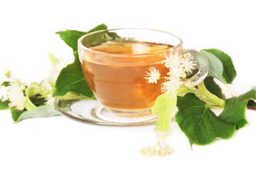 Linden tea on a white table in a glass cup. Flower tea, herbal medicine.