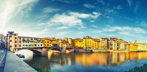 Scenic view on Ponte Vecchio in Florence, Italy, on a summer day. Colorful travel background....