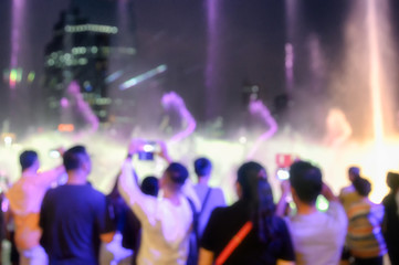 Blurred scene people seeing show of laser light with fountain event