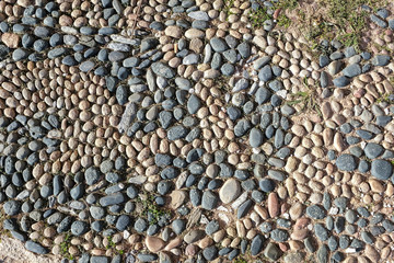 Particolore structure of some streets made of sea stones, in old street in medieval town.