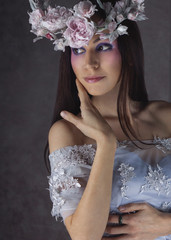 Fashion Portrait of Young Woman with Beautiful Flower Wreath Hairstyle and Fashion creative Makeup.