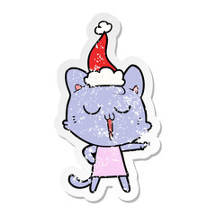 distressed sticker cartoon of a cat singing wearing santa hat