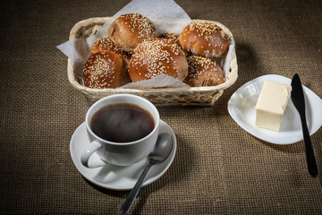 Traditional breakfast with hot drink and fresh sesame buns.