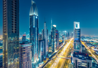 Fototapeta na wymiar Skyscrapers and highways in downtown Dubai, UAE. Nighttime skyline of a big modern city.
