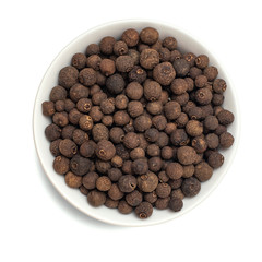 Allspice spice in bowl isolated on white background. Top view