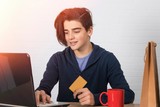 young man with credit card and laptop buying online