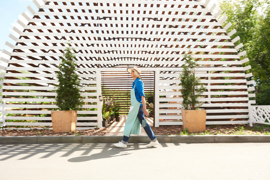 Background image of senior worker walking past greenhouse in planttion, copy space