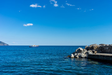 Italy, Cinque Terre, Monterosso, a blue and white boat sitting next to a body of water