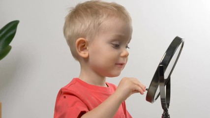 Cute kid playing with mom's cosmetics. Closeup portrait. Beauty, makeup concept