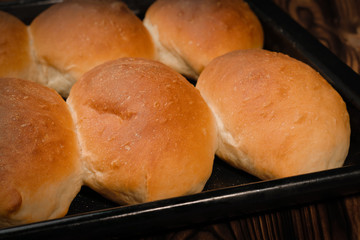 Fresh baked pies on black baking tray close up