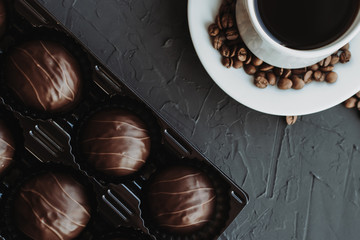 Chocolate cakes and cup of coffee on dark background