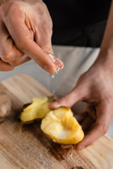 Fresh hot boiled potato with peeled skins. Hand holding ready to cook or eat, on table. Concept and idea of food rustic still life style