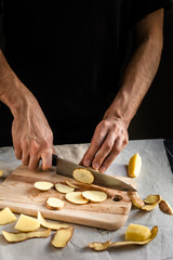 Cooking potato chips. Chef slicing fresh potato. Healthy food.