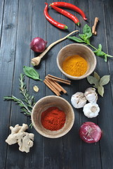 Colorful various of fresh and dried herbs, spices for cooking. Spice and herb seasoning, paprika powder, cinnamon, red onion. garlic, basil, ginger root on dark background