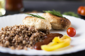 Chicken cutlets with buckwheat, herbs, ketchup and tomatoes