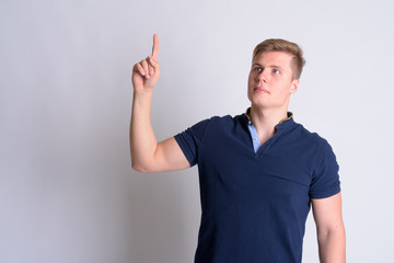 Fototapeta premium Portrait of young blonde handsome man thinking and pointing up