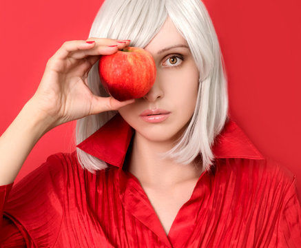 Blonde woman in red shirt  holding red apple