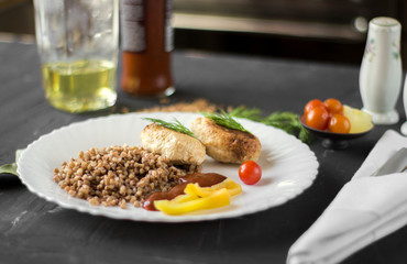 Chicken cutlets with buckwheat, herbs, ketchup and tomatoes