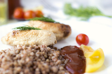 Chicken cutlets with buckwheat, herbs, ketchup and tomatoes