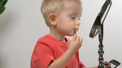 Cute kid playing with mom's cosmetics. Closeup portrait. Beauty, makeup concept