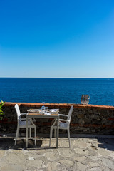 Italy, Cinque Terre, Monterosso, a chair sitting in front of a body of water