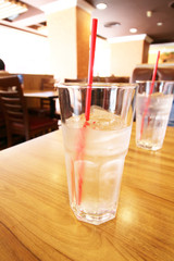 glass of water with ice cubes on wooden table