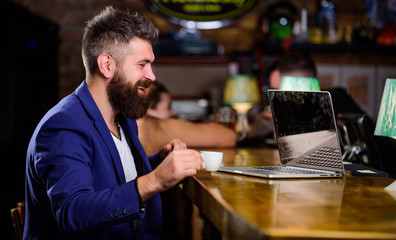 Hipster freelancer work online blog notebook. Surfing internet. Online job. Man bearded businessman sit pub with laptop and cup of coffee. Freelance benefit. Manager work online while enjoy coffee