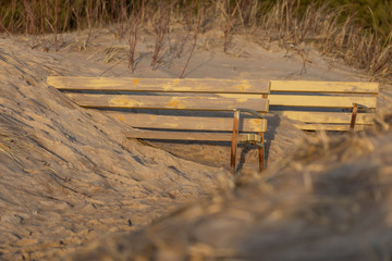 Bench covered by sand dunes, lovely sunset in Lithuania