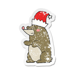 retro distressed sticker of a cartoon bear wearing christmas hat