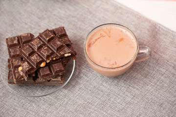 Hazelnut and almond milk and dark chocolate pieces tower. Chocolate bars on table with chocolate tower. Chocolate and nuts and choco swirl.