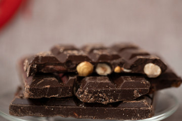 Hazelnut and almond milk and dark chocolate pieces tower on wooden background.