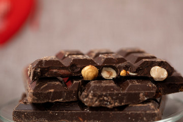 Hazelnut and almond milk and dark chocolate pieces tower on wooden background.