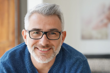 Portrait of smiling man with grey hair and glasses