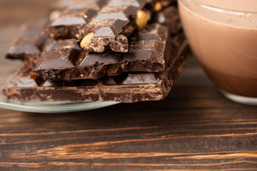 Hazelnut and almond milk and dark chocolate pieces tower. Chocolate bars on table with chocolate tower. Chocolate and nuts and choco swirl