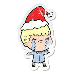 distressed sticker cartoon of a man crying wearing santa hat