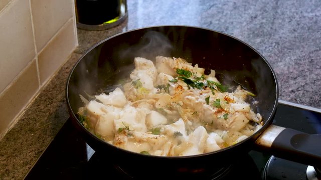 cooking of fresh fish, cod fillets with addition of cream, herbs and lemon