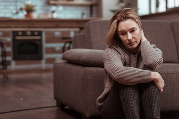 Woman wearing brown squared trousers feeling depressed