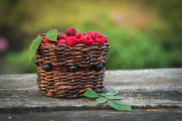 Fototapeta na wymiar ripe raspberries in a basket on the background of nature